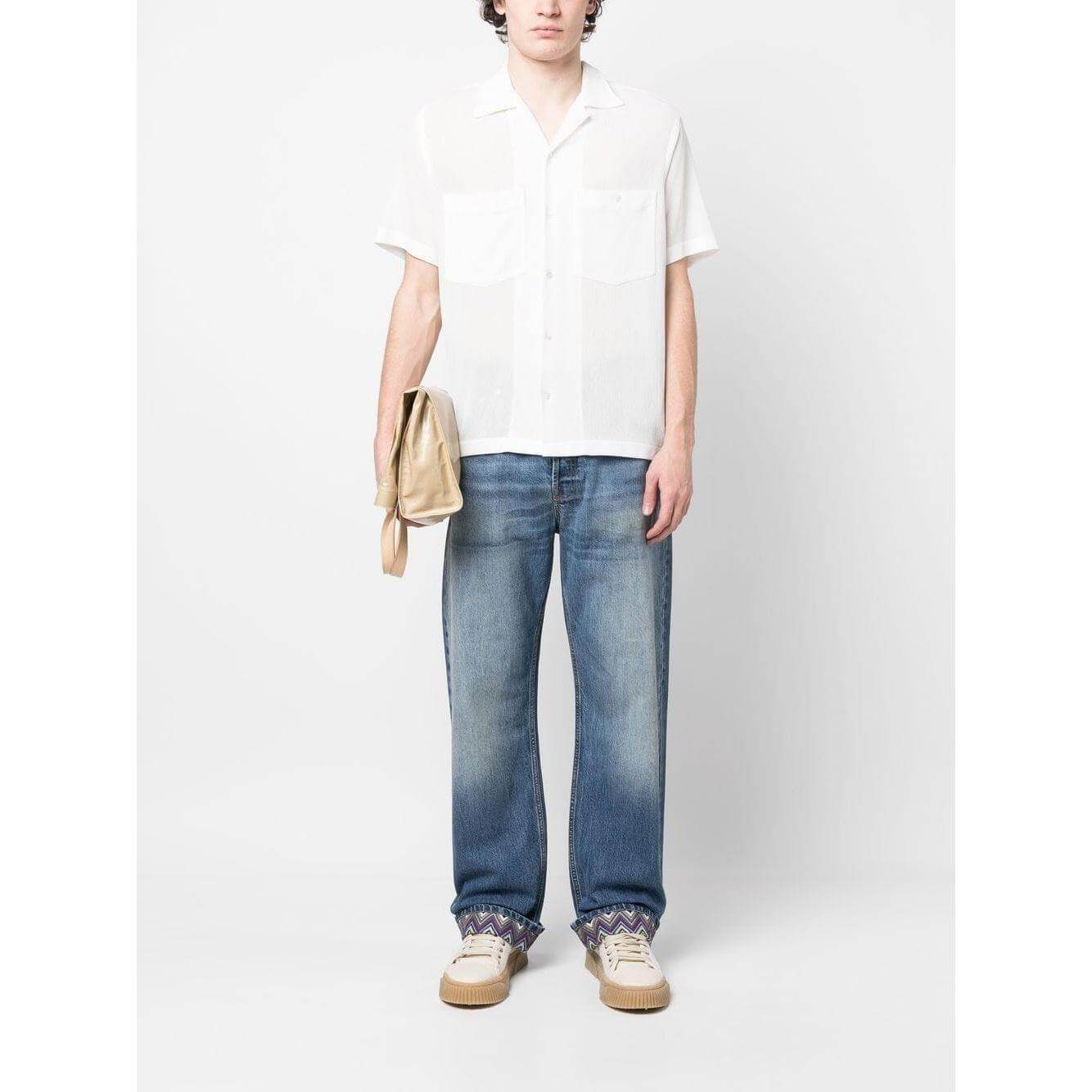 Model wearing Missoni stonewashed blue jeans with zigzag hem, straight leg style.