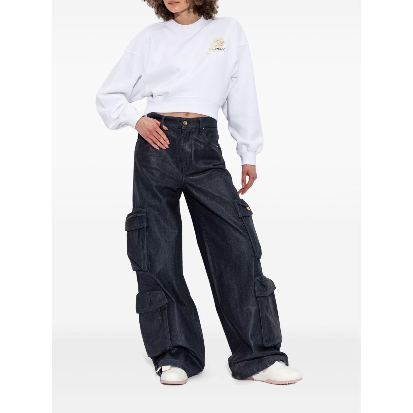 Model wearing Off White cropped sweater with rear graphic print and ribbed cuffs, paired with dark cargo pants and sneakers.