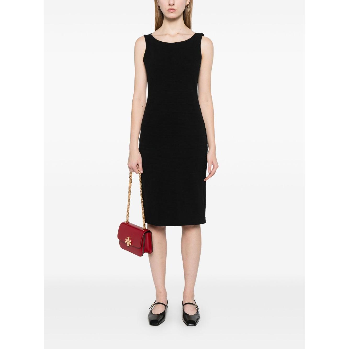 Woman wearing Emporio Armani black ottoman jersey sheath dress with red handbag and black shoes, sleeveless design