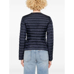 Person wearing a black puffer jacket and light blue jeans on a white background