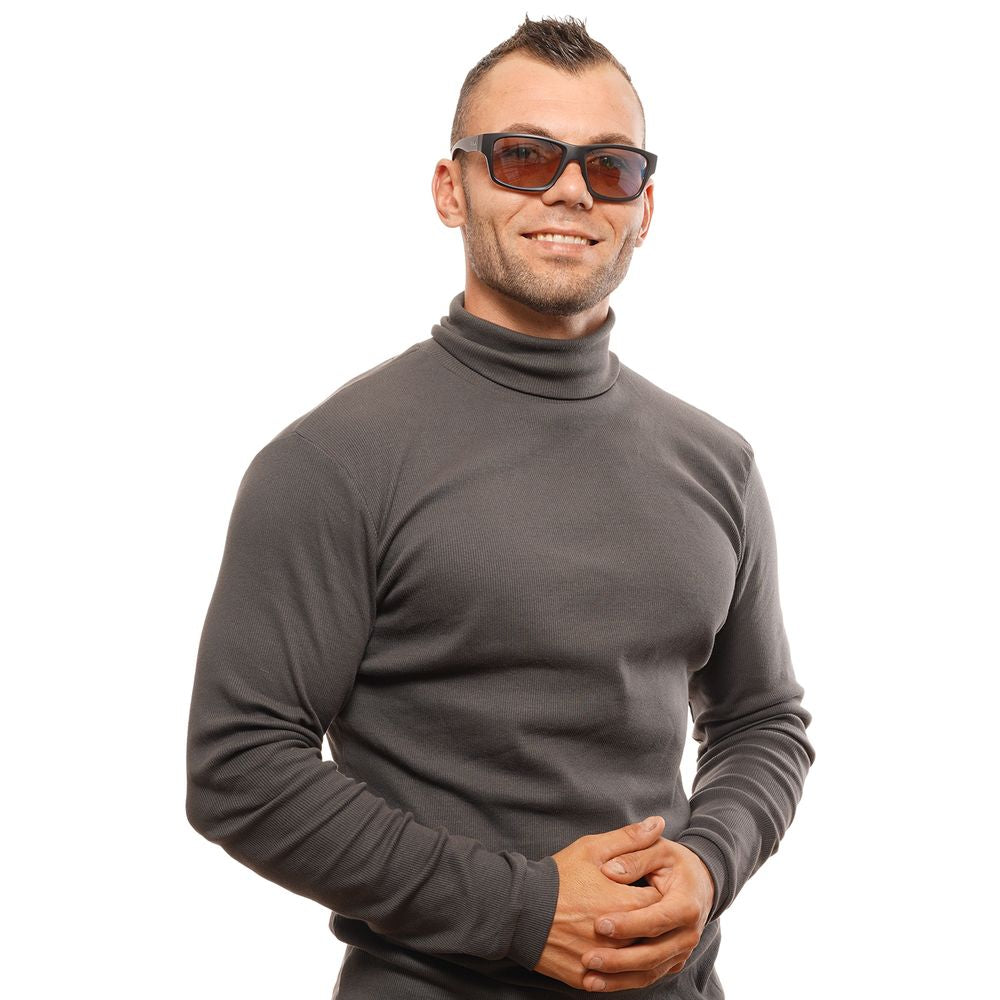 Man wearing Bolle black unisex sunglasses with trapezium photochromatic lenses and full-rim black frame, standing with a smile.
