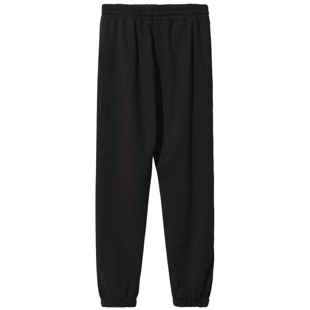 Comme Des Fuckdown black cotton sweatpants with drawstring waist and side pockets, featuring logo print on front and sides.