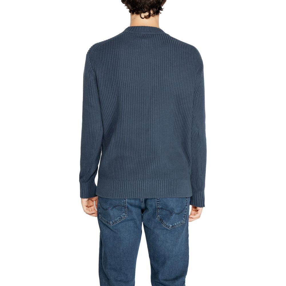 Back view of a man wearing a black Calvin Klein organic cotton sweater with jeans, highlighting a ribbed knit design.