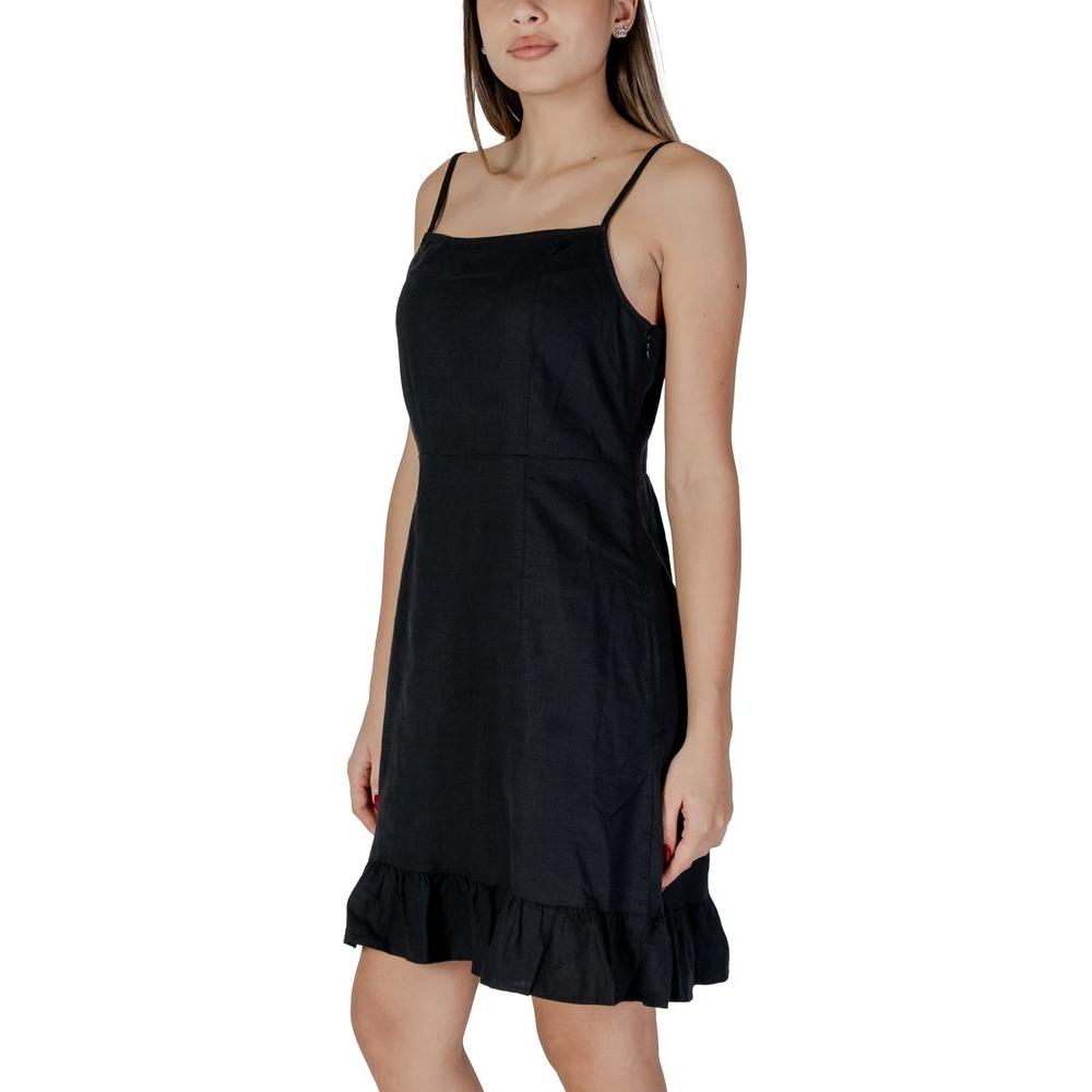 Woman wearing B.Young black linen dress with straps, perfect for spring/summer. Made of 52% linen and 48% viscose for comfort.