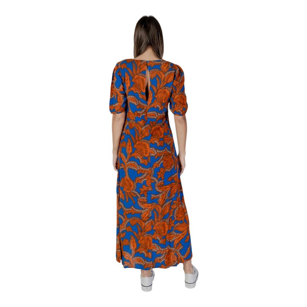 Back view of a woman wearing a B.Young blue viscose dress with orange floral pattern from the Spring/Summer collection.