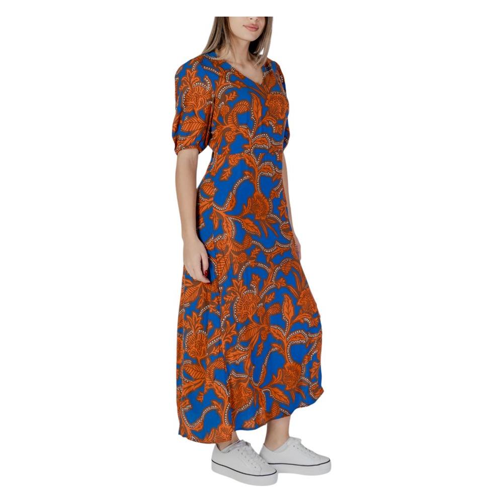 Woman wearing a blue and orange floral B.Young dress, showcasing women's spring/summer collection, made of 100% viscose.