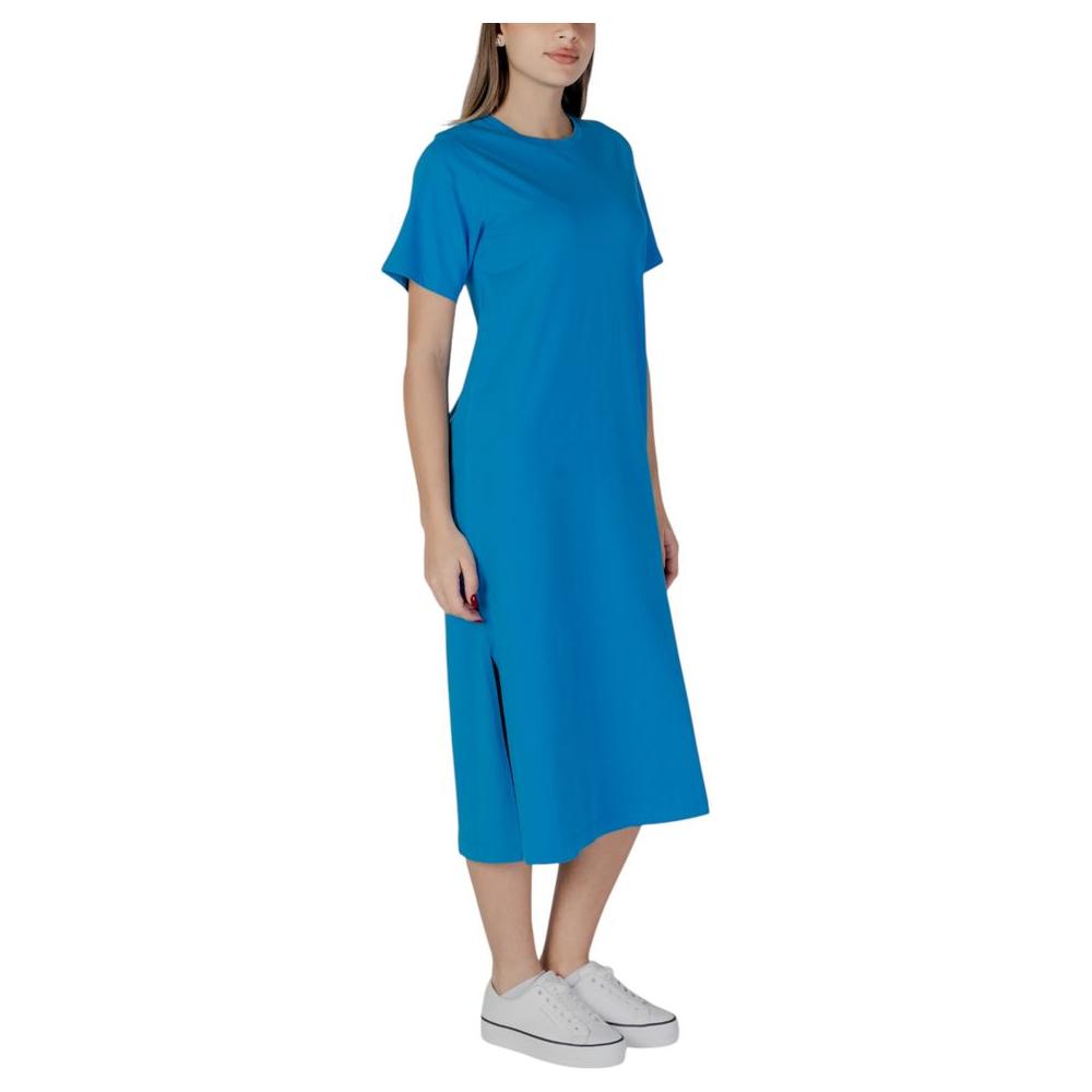 Woman wearing B.Young blue cotton dress, ideal for spring-summer, made from 100% cotton, showcasing casual elegance.