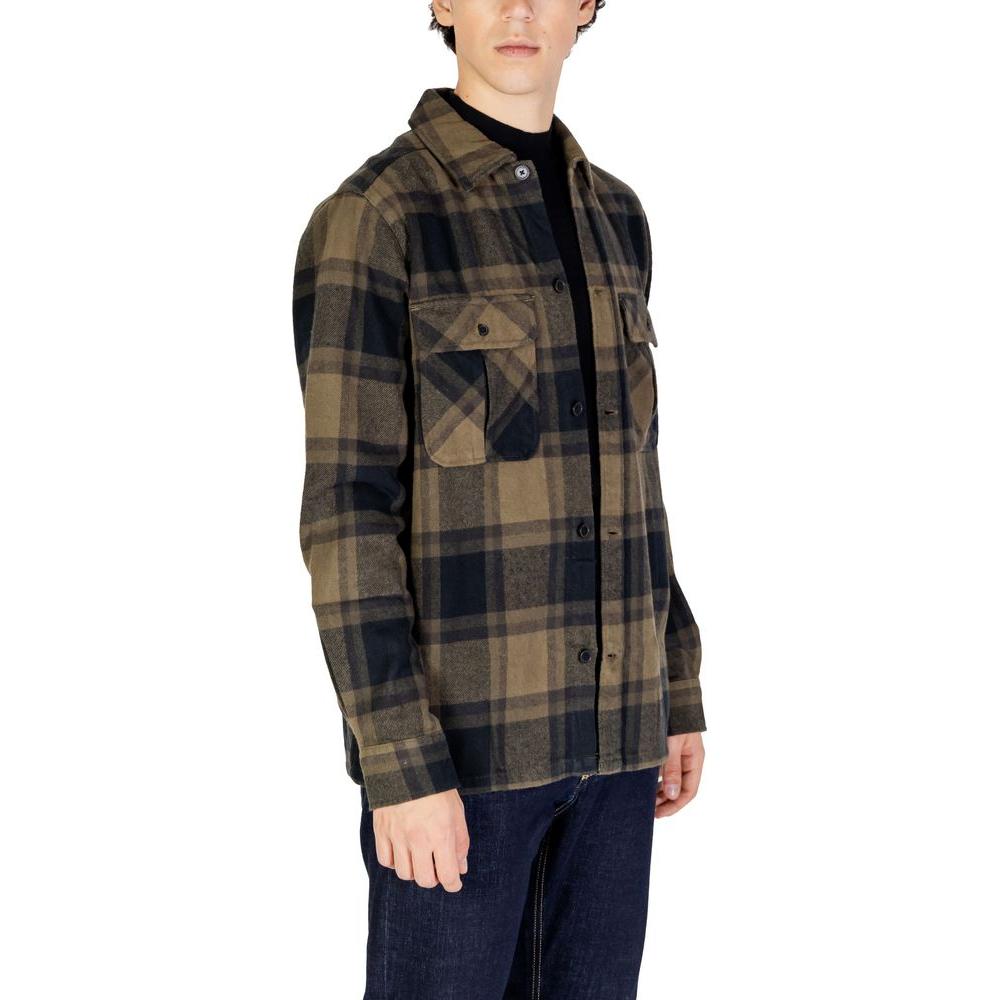 Men's plaid flannel shirt with button front, fall/winter collection, featuring chest pockets, worn by a model with dark jeans.