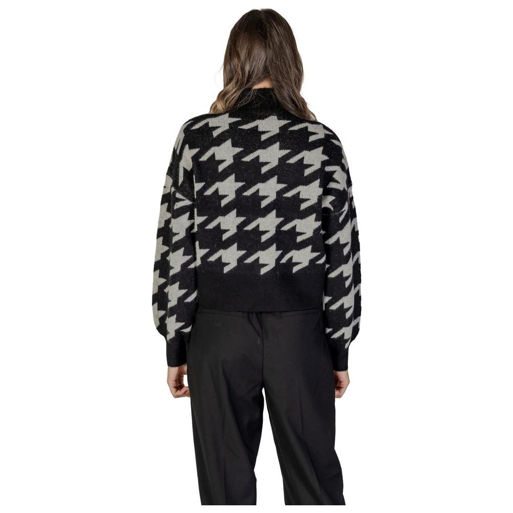 Back view of woman wearing Vero Moda black acrylic sweater with houndstooth pattern, part of the fall/winter women's knitwear collection.