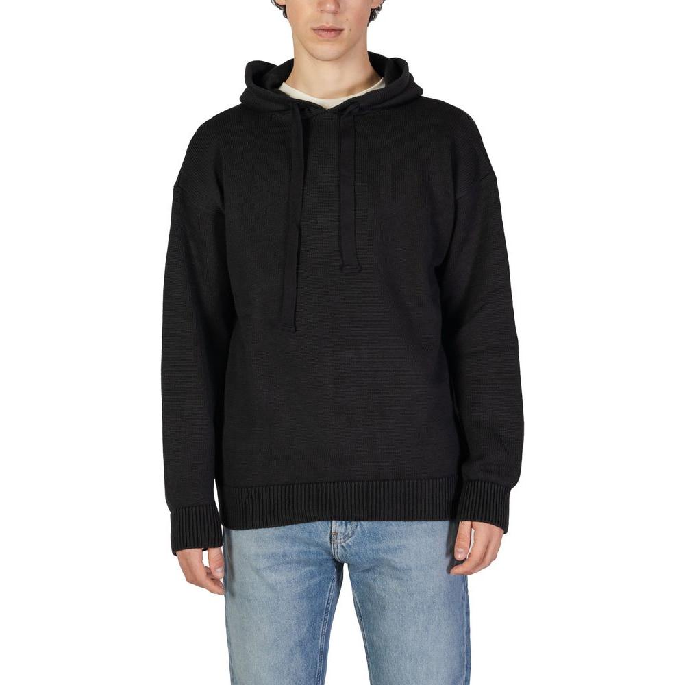 Underclub black cotton sweater for men, fall/winter knitwear collection, 50% cotton 50% acrylic, modeled with blue jeans.