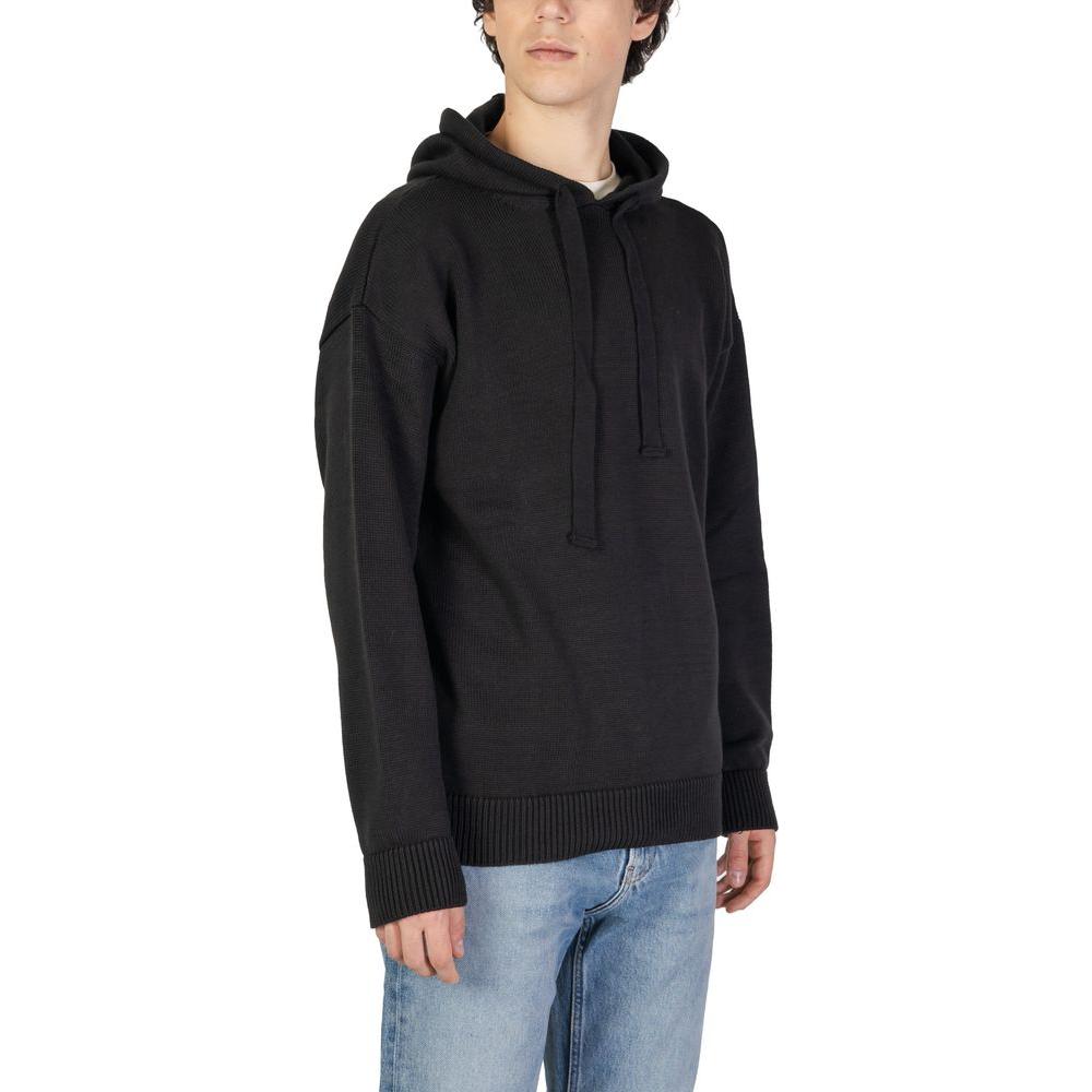 Alt Tag: Man wearing Underclub black cotton sweater, part of men's knitwear for fall/winter. Made of 50% cotton, 50% acrylic.