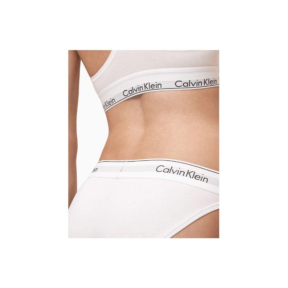 Woman wearing Calvin Klein white cotton underwear with logo waistband, showcasing comfort and minimalist design.