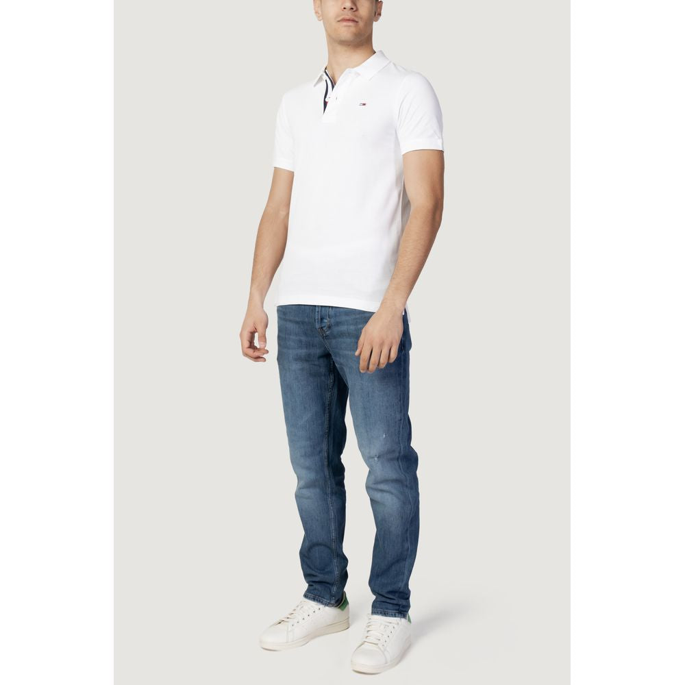Tommy Hilfiger white cotton polo shirt for men, fall/winter collection, paired with blue jeans and white sneakers, stylish casual wear.