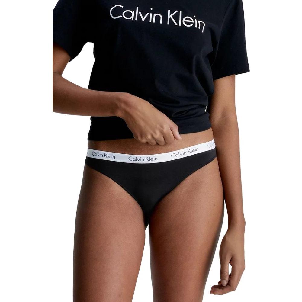 Woman wearing Calvin Klein black bikini underwear and t-shirt, showcasing comfortable fit and stylish design.