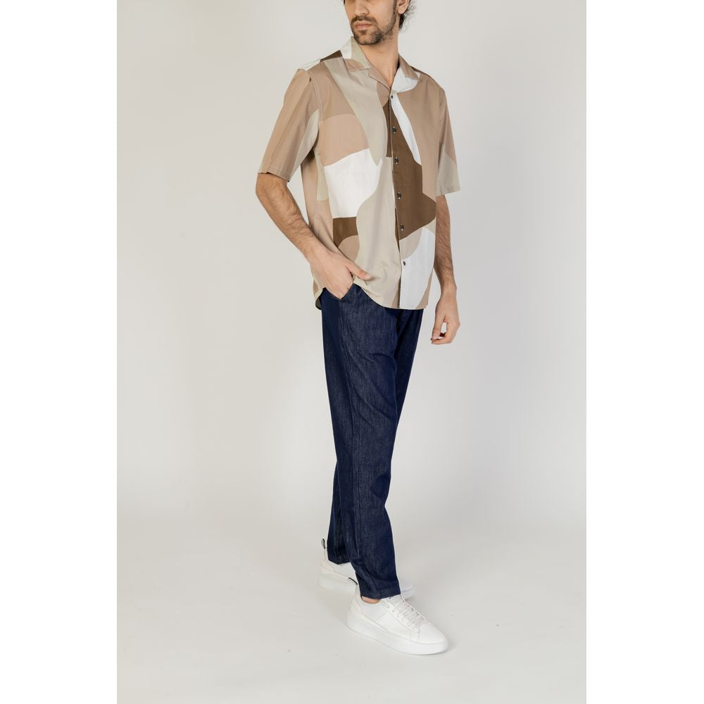 Man wearing Only & Sons brown cotton short sleeve shirt, part of spring/summer collection, paired with jeans and white sneakers.