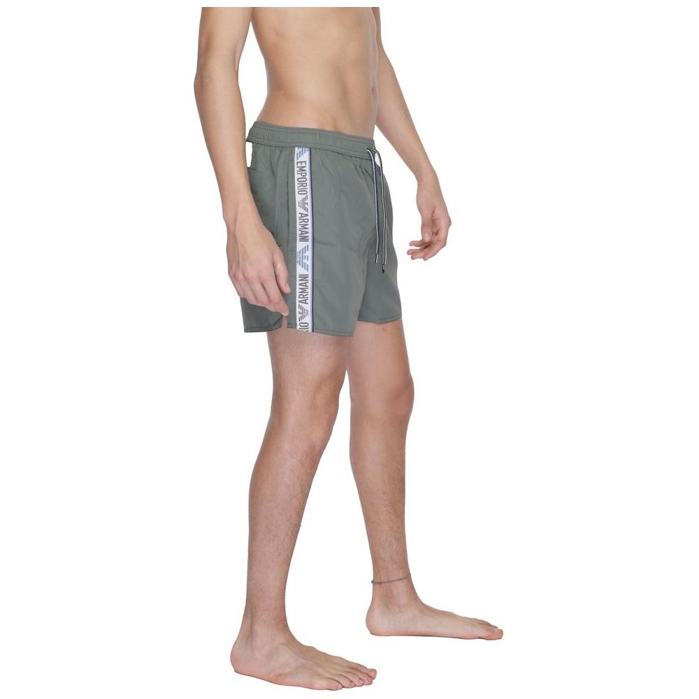 Model wearing Emporio Armani green polyester boxer swimwear, showcasing the brand's stylish design and lightweight comfort.