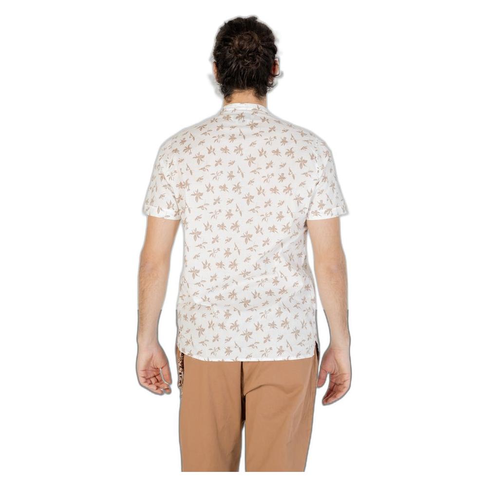 Back view of a man wearing a white short-sleeve shirt with a brown palm leaf pattern, paired with tan pants, displaying spring/summer style.