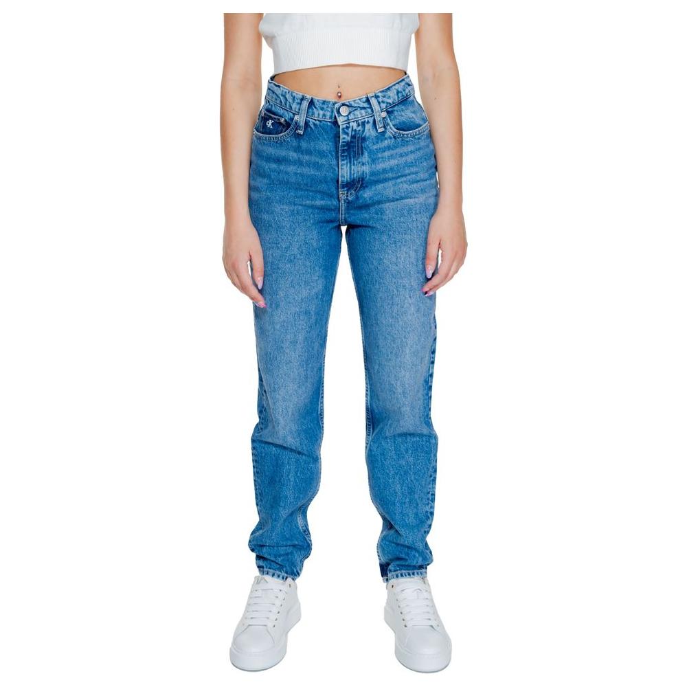 Woman wearing Calvin Klein blue mom jeans made from 80% cotton, 20% recycled cotton, autumn/winter collection, white sneakers.