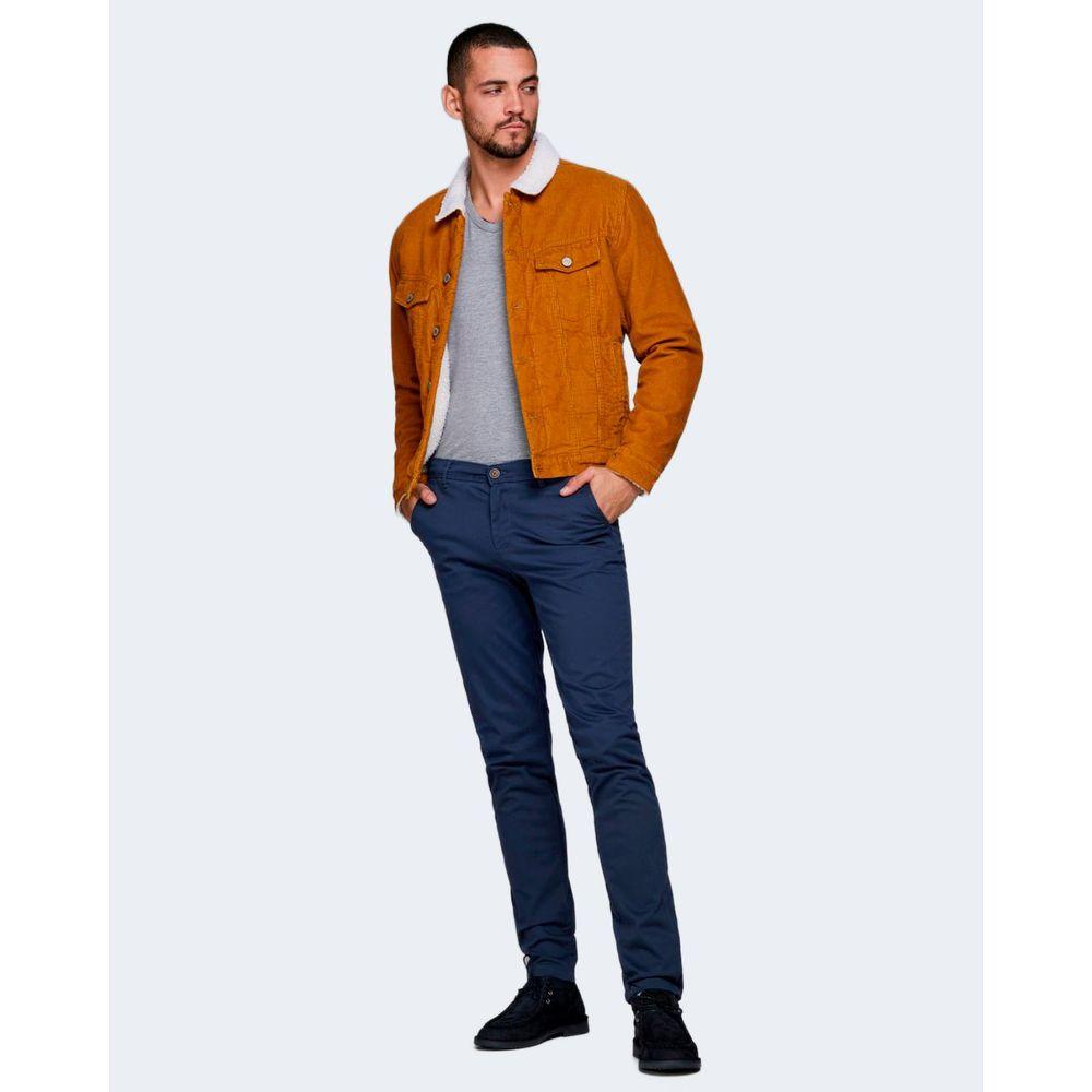 Man wearing Jack Jones blue slim fit cotton jeans paired with a brown jacket and grey shirt, showcasing stylish casual wear.