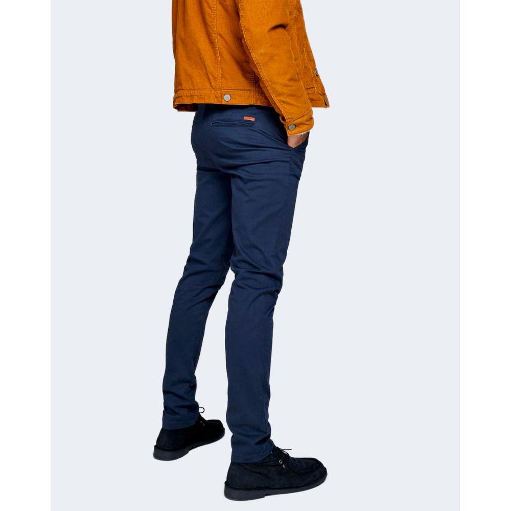 Model wearing Jack Jones blue cotton slim fit jeans with orange jacket, showcasing versatile style for casual or night out.