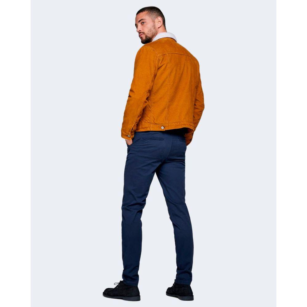 Model wearing Jack Jones blue cotton jeans with brown jacket, showcasing slim fit and modern style for versatile occasions.