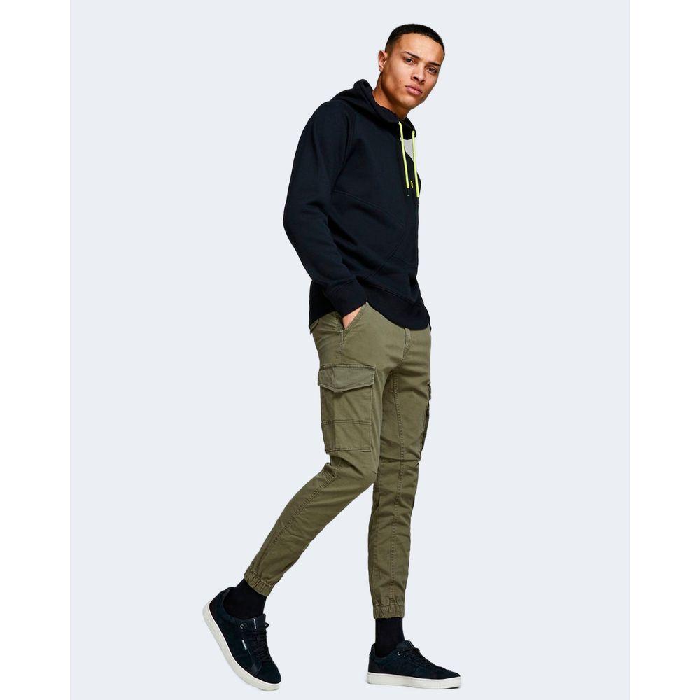 Man wearing Jack Jones green cotton pants with a black hoodie, showcasing slim fit and casual style.