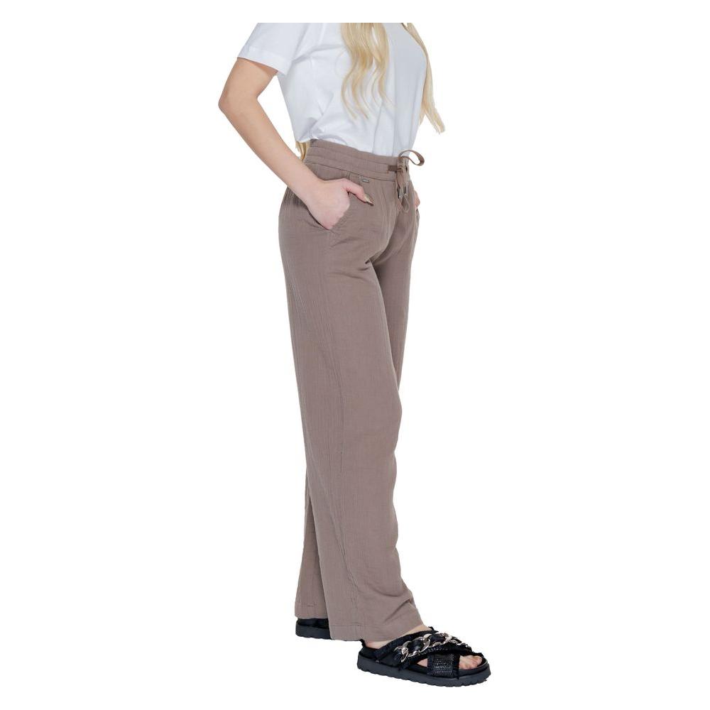 Woman wearing Street One brown cotton palazzo pants for spring and summer collection, styled with a casual white top and black sandals.