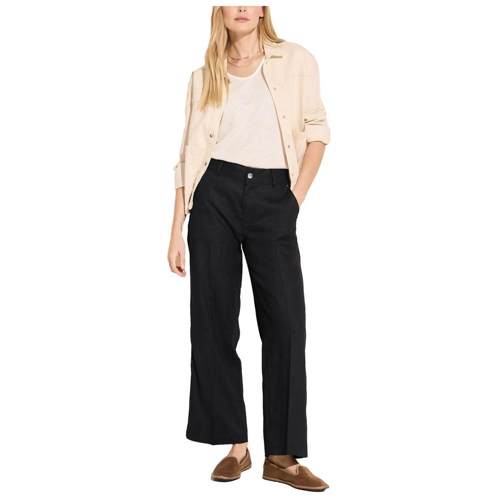 Woman wearing black linen palazzo pants from Street One's Spring/Summer collection, styled with a beige jacket and casual shoes.