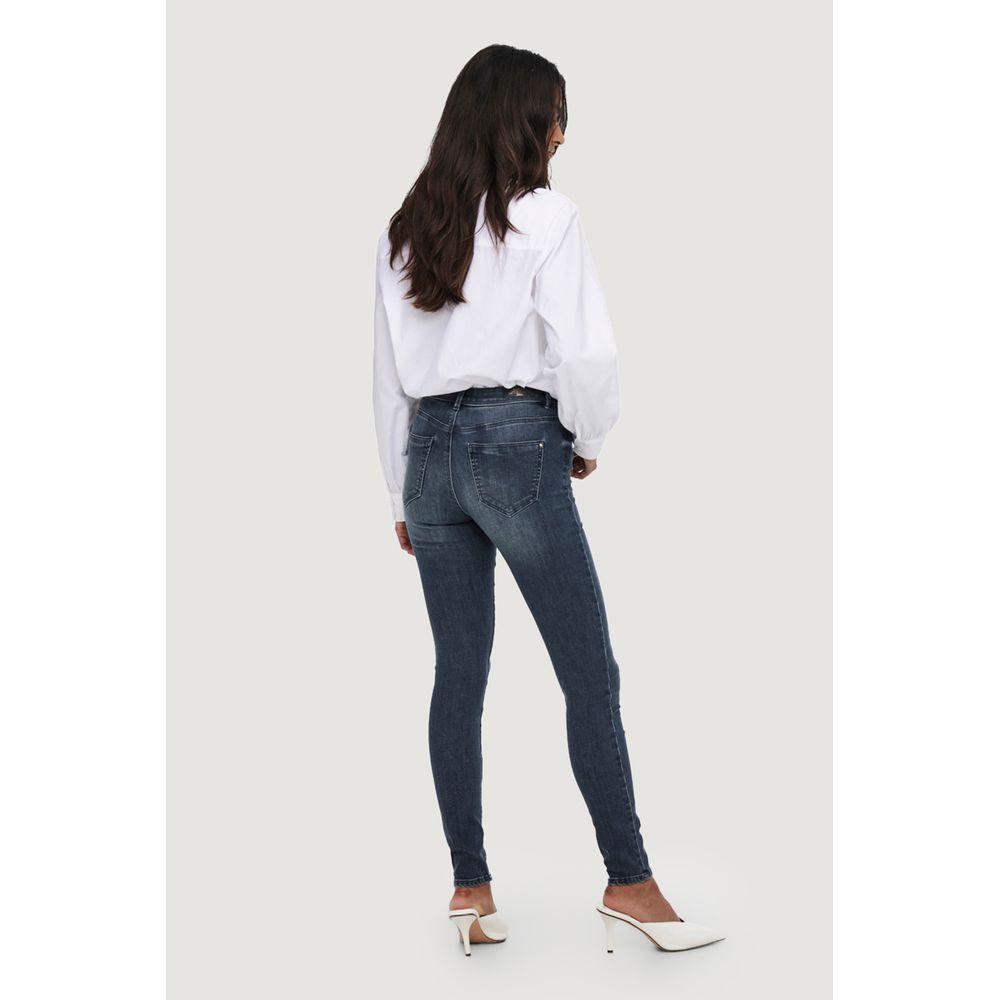 Woman wearing Only blue skinny jeans with a white blouse and heels, showcasing a comfortable and stylish fit for versatile occasions.