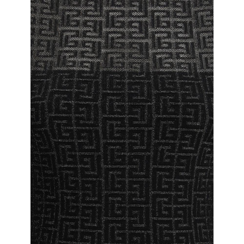Close-up of Balmain knit mini dress fabric with iconic logo pattern, featuring intricate black and gray woven design.