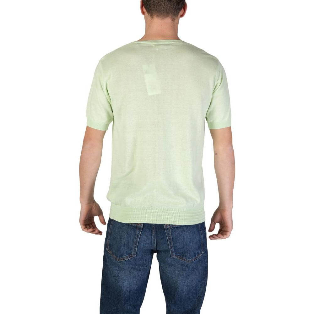 Back view of a man wearing a Hamaki-Ho Green Cotton T-Shirt from the men's fall/winter collection, paired with jeans.