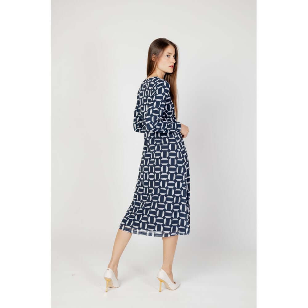 Woman wearing Street One blue polyester long dress, fall/winter collection with geometric print, side view, white background.
