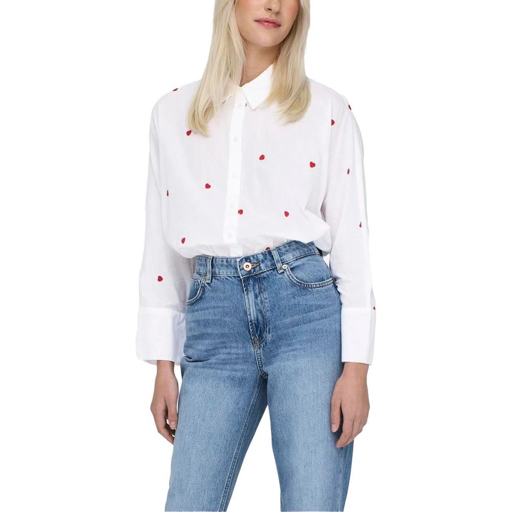 Women's long sleeve white cotton shirt with red details paired with blue jeans.