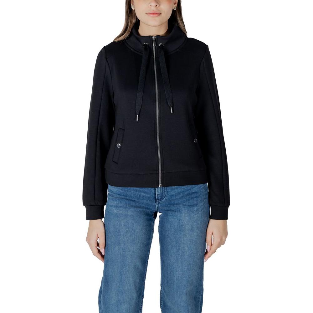 Woman wearing a Street One black cotton sweater with zip front and drawstring hood, paired with blue jeans.