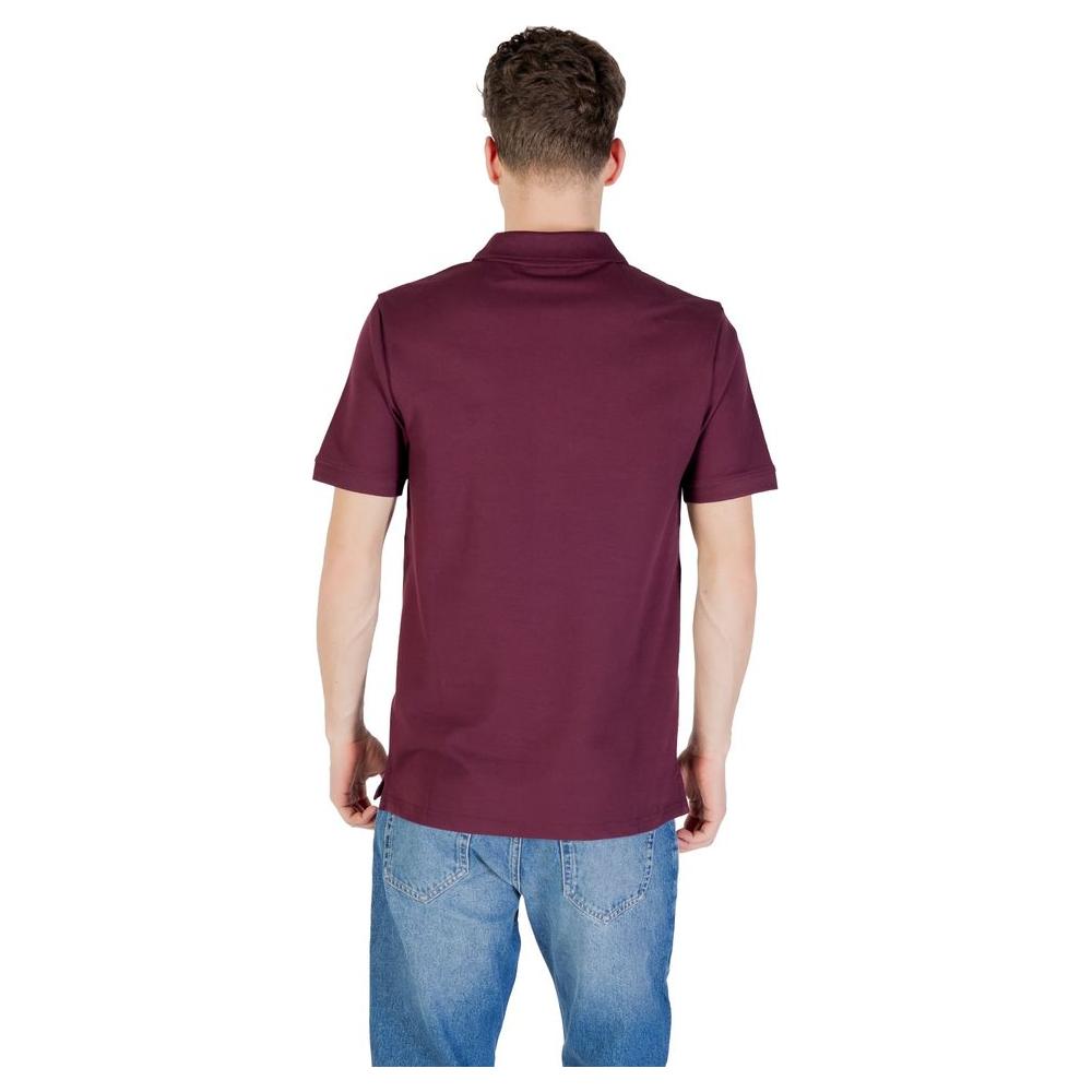 Back view of a man wearing a Lyle & Scott Bordeaux Cotton Polo Shirt, paired with blue jeans, showcasing the shirt's fit and style.