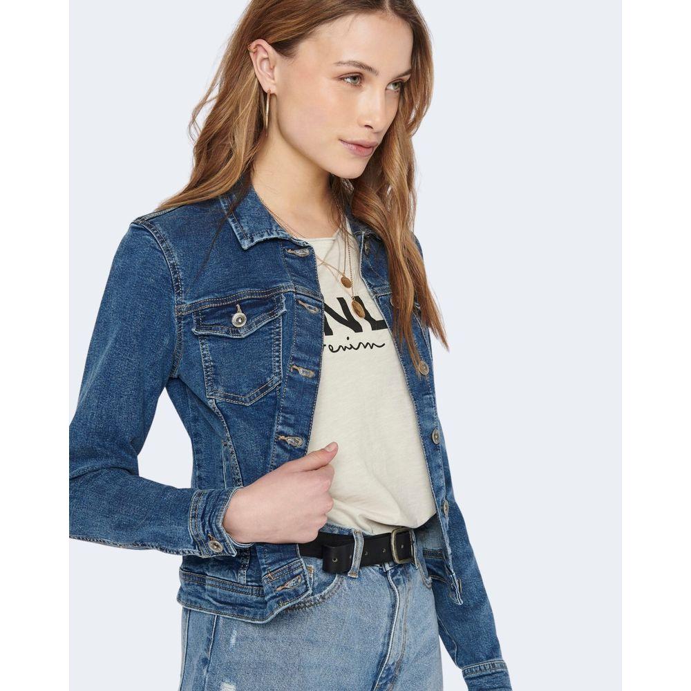 Woman wearing Only blue cotton denim jacket with modern details, paired with a graphic tee and jeans, showcasing versatile style.