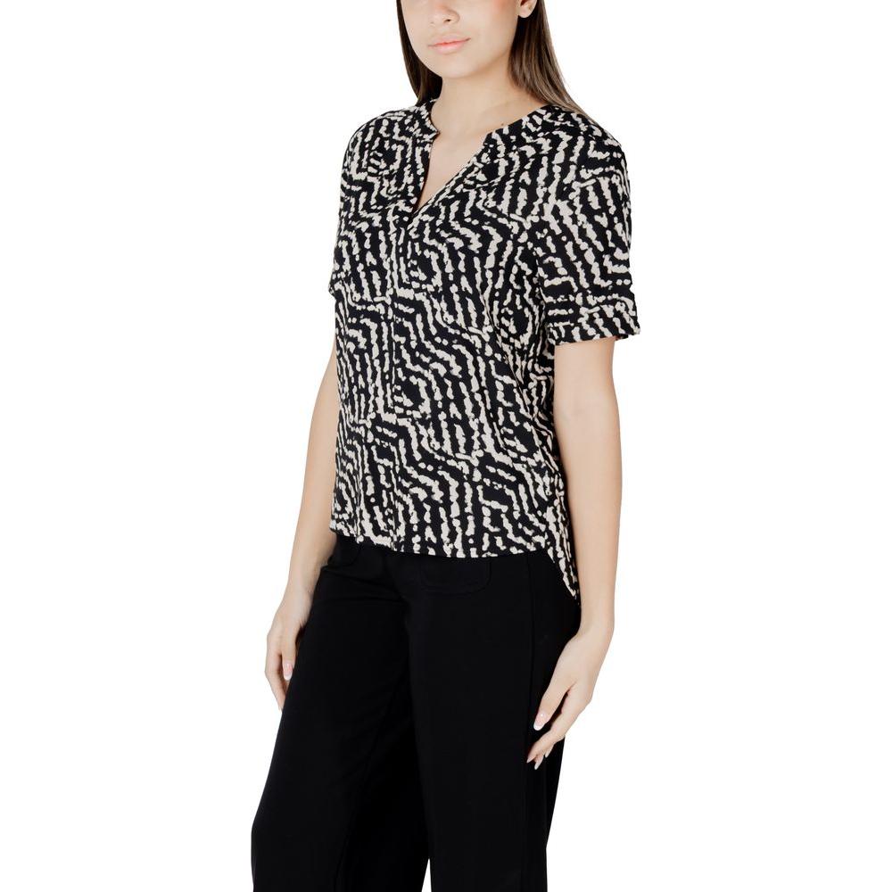 Woman wearing Street One black viscose short-sleeve blouse with abstract pattern, V-neck design, paired with black trousers.
