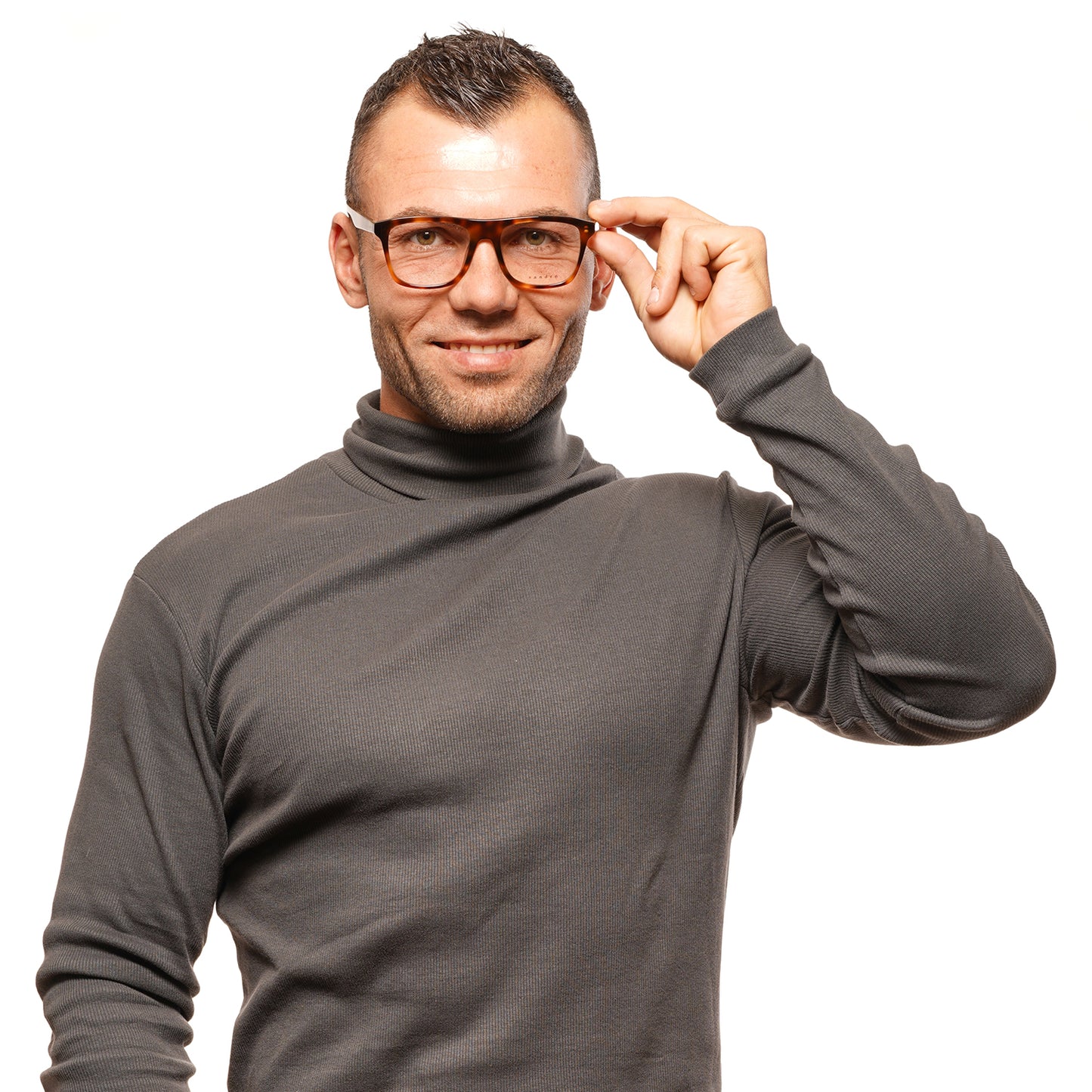 Person wearing glasses and a gray turtleneck sweater, smiling against a white background.