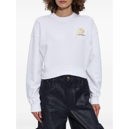 White cropped Off White sweater with a crew neck, graphic print roses and arrows, worn by a model wearing jeans.