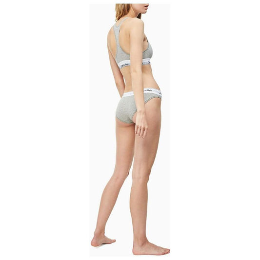 Model wearing Calvin Klein gray cotton underwear bikini briefs with logo waistband, showcasing minimalist and comfortable design.